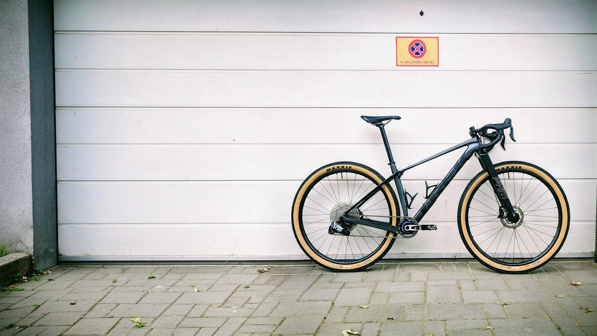 A gravel bike parked against a garage door